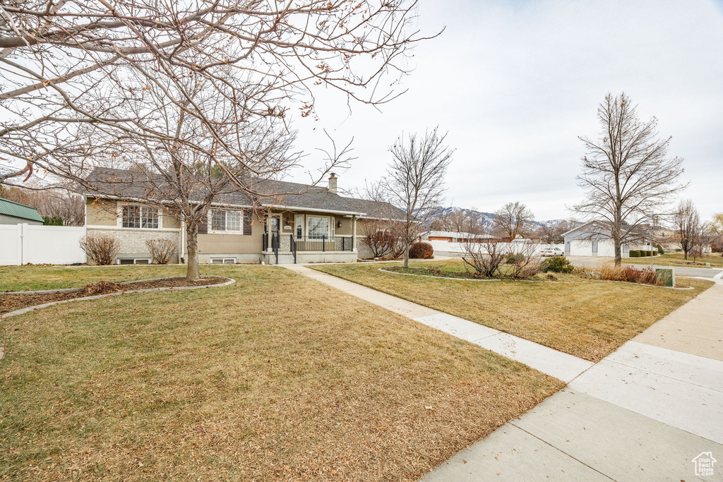 Single story home with covered porch and a front yard