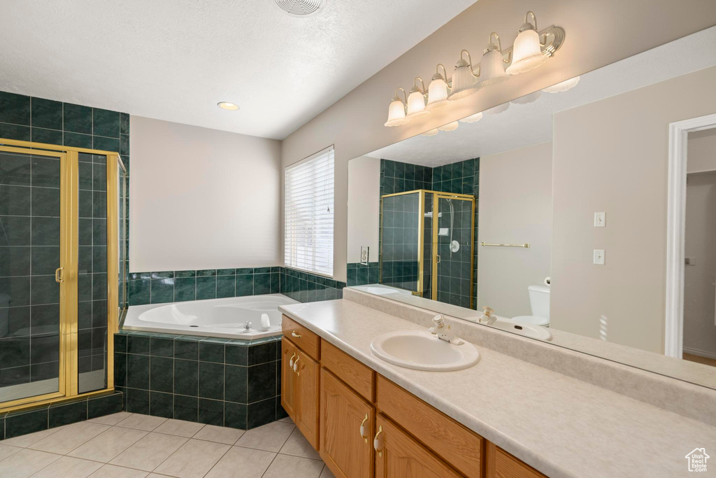 Full bath with a garden tub, tile patterned floors, a stall shower, and vanity