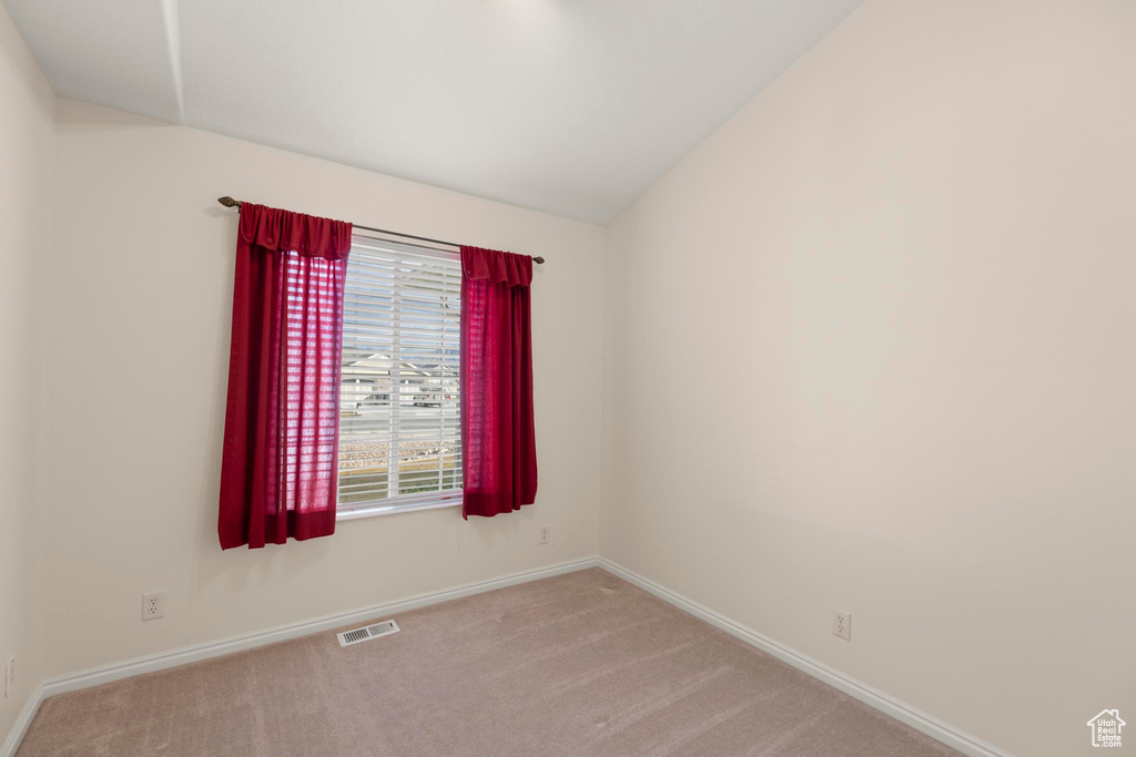 Carpeted spare room with baseboards and visible vents