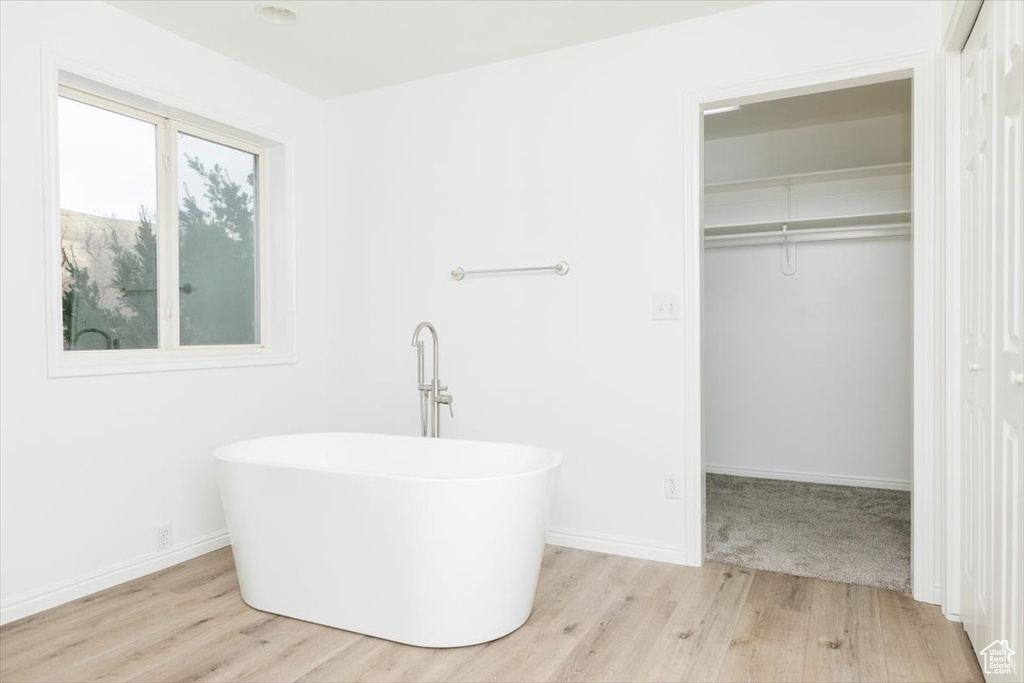 Bathroom with hardwood / wood-style flooring and a bathtub