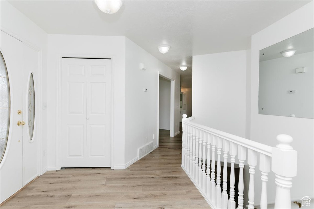 Hallway with light hardwood / wood-style flooring