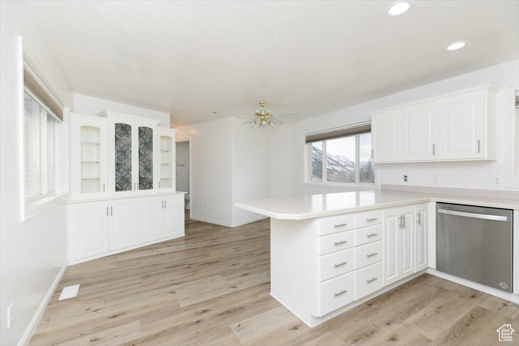 Kitchen with white cabinetry, dishwasher, kitchen peninsula, and light wood-type flooring