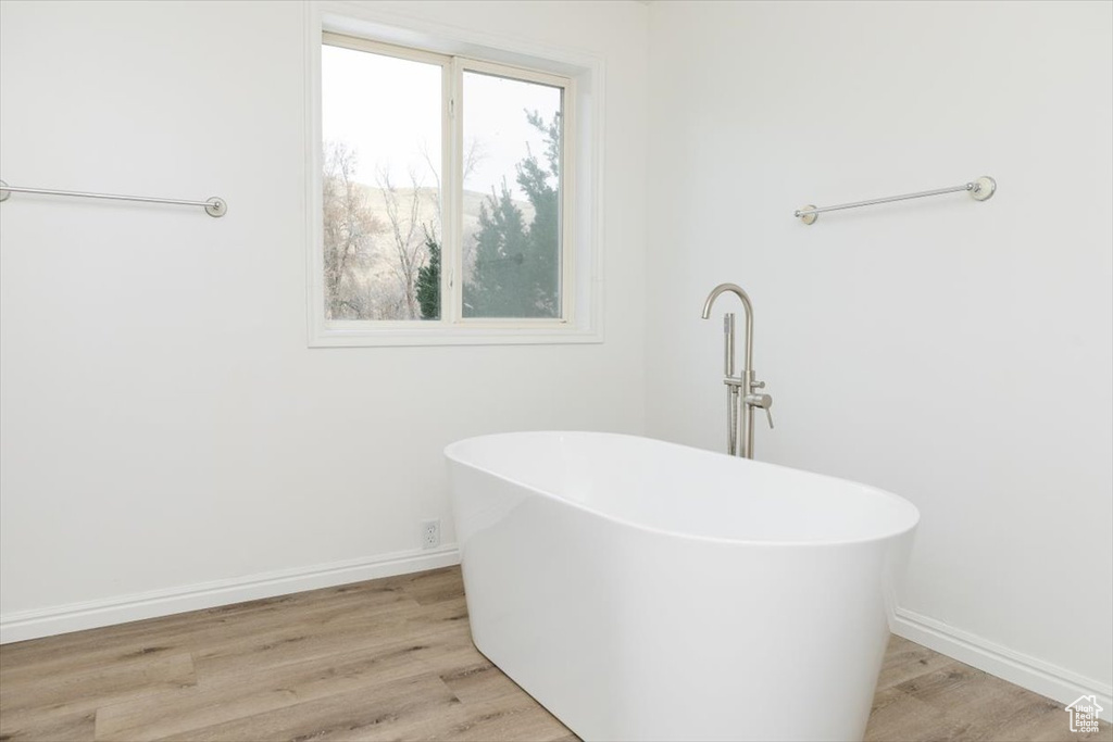 Bathroom with hardwood / wood-style flooring and a tub