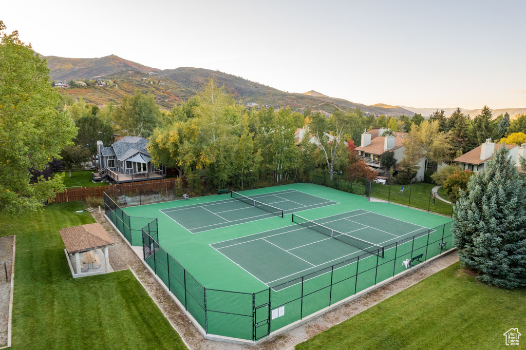 View of sport court with a mountain view and a yard
