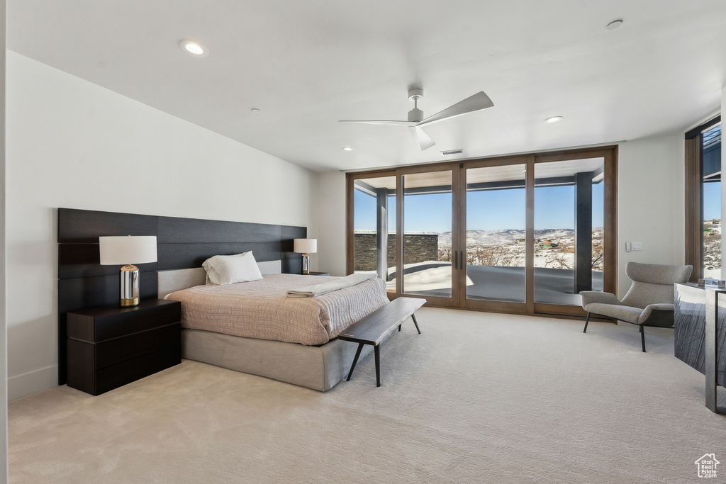 Carpeted bedroom with ceiling fan, floor to ceiling windows, and access to outside