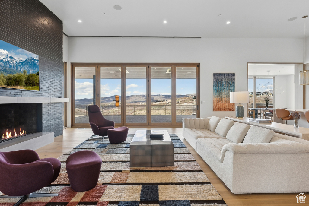 Living room featuring wood finished floors, plenty of natural light, a fireplace, a mountain view, and recessed lighting