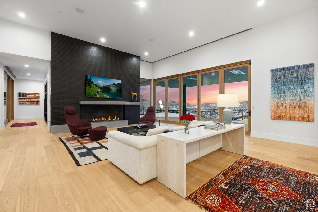 Living room with light hardwood / wood-style floors and a large fireplace
