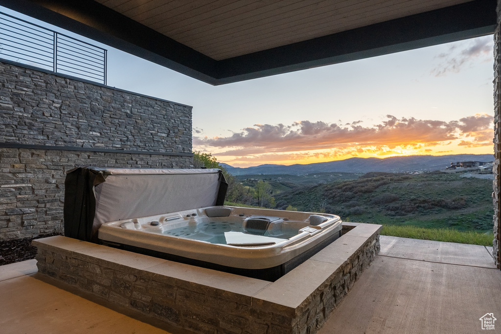 View of patio / terrace featuring a covered hot tub and a mountain view