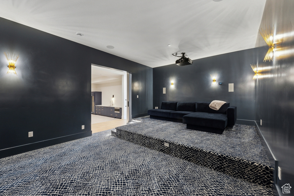 Carpeted home theater room with baseboards