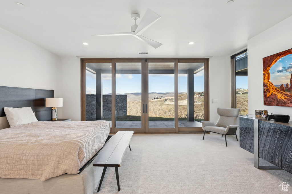 Bedroom with a wall of windows, access to outside, carpet floors, and recessed lighting