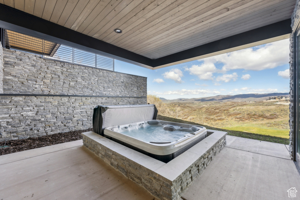 View of patio featuring a covered hot tub and a mountain view