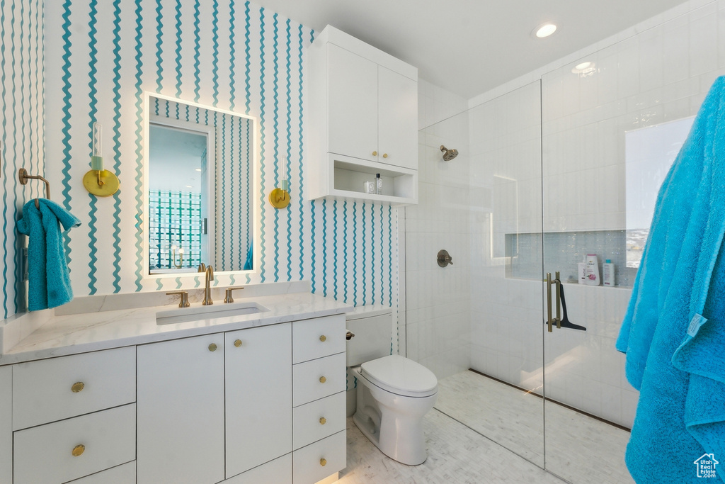 Bathroom with tile patterned floors, vanity, toilet, and a shower with shower door