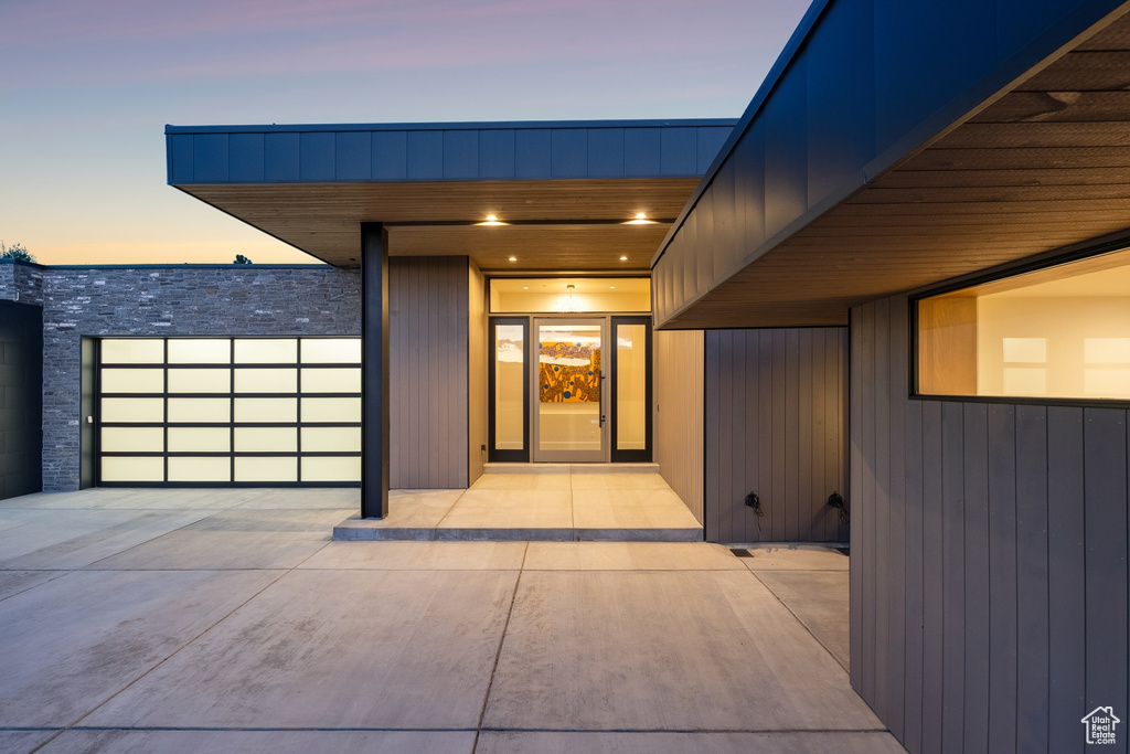 Exterior entry at dusk featuring stone siding