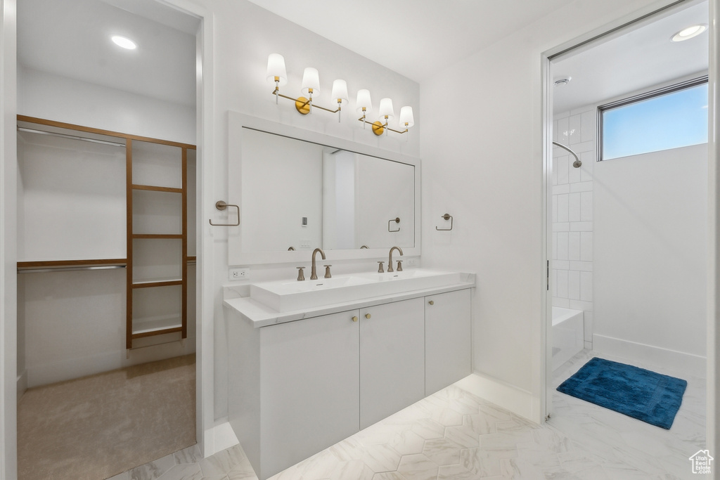 Bathroom featuring tiled shower / bath combo and vanity