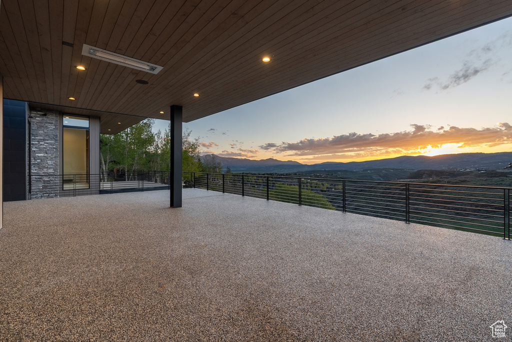 Patio terrace at dusk featuring a mountain view
