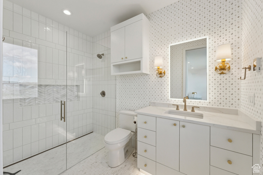 Full bath featuring a shower stall, toilet, wallpapered walls, and vanity