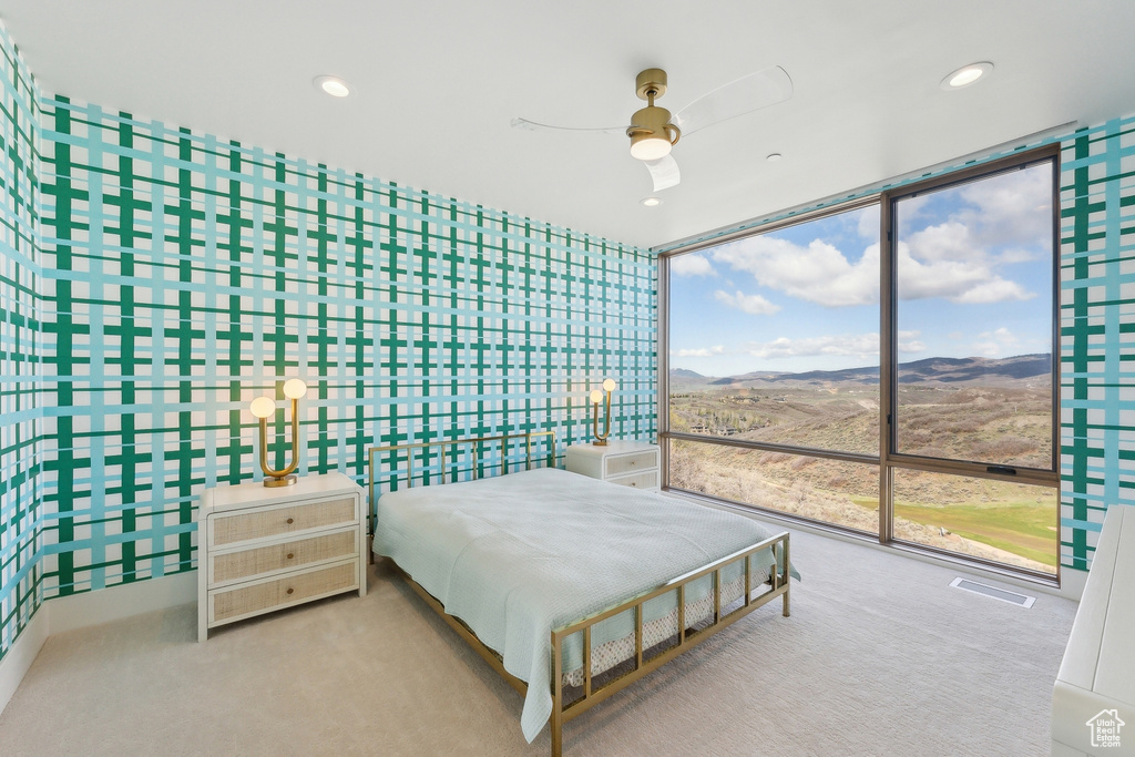 Bedroom with multiple windows, expansive windows, recessed lighting, a mountain view, and a ceiling fan