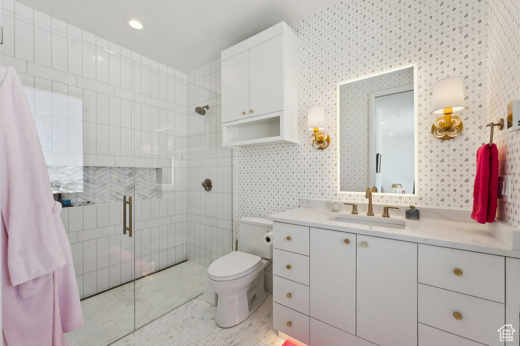 Bathroom featuring vanity, toilet, and a shower with shower door