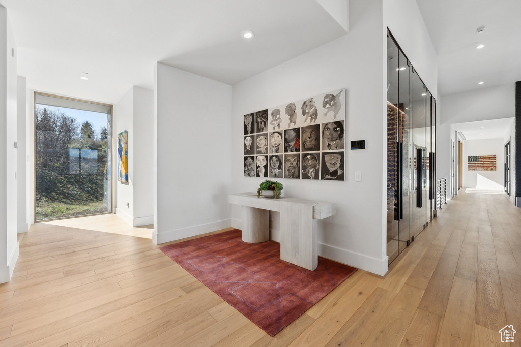 Hallway featuring light wood-style flooring, baseboards, and recessed lighting