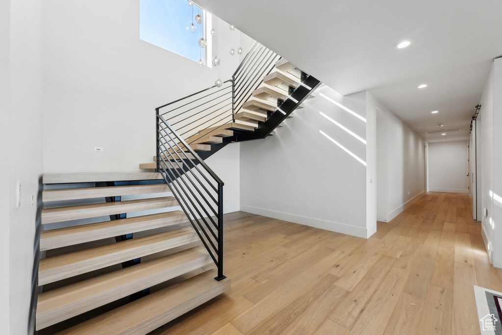 Stairway with hardwood / wood-style floors, recessed lighting, and baseboards