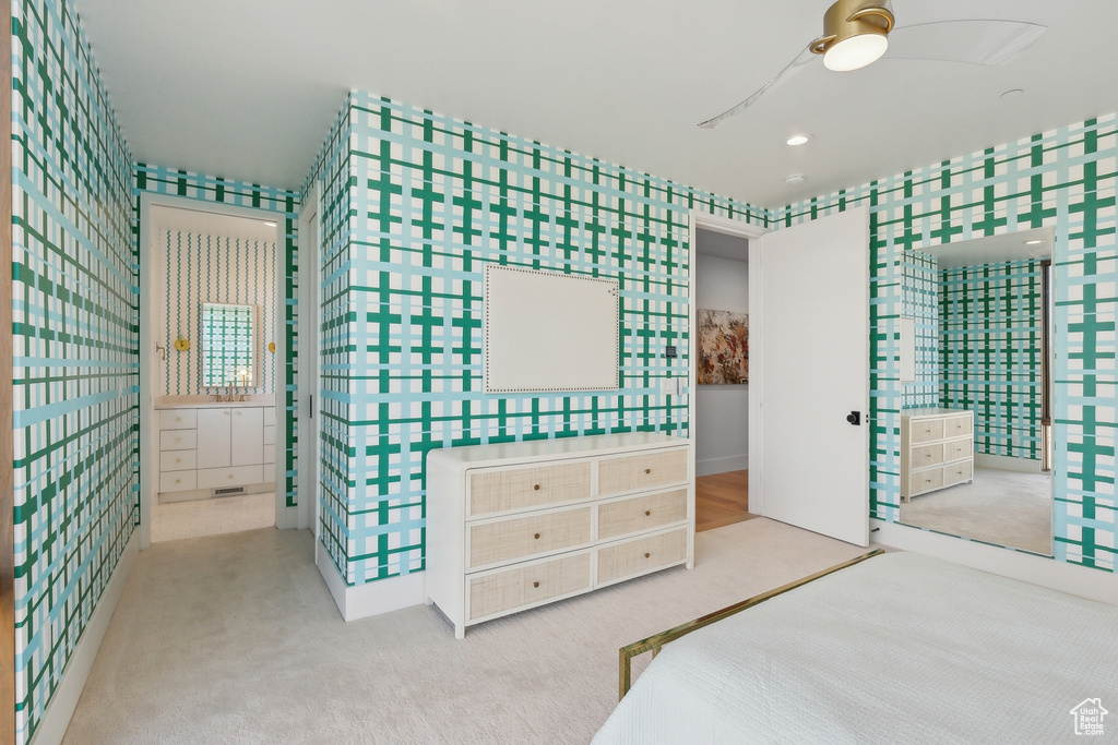 Unfurnished bedroom featuring carpet, wallpapered walls, ensuite bathroom, and a ceiling fan