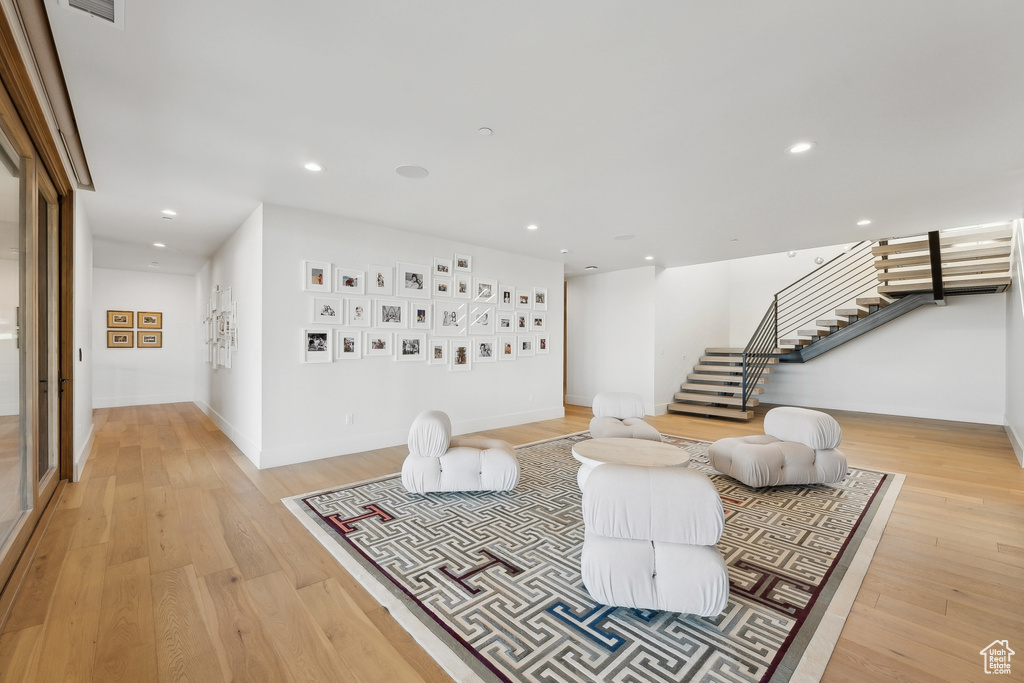 Living area with stairway, light wood-style flooring, recessed lighting, and baseboards