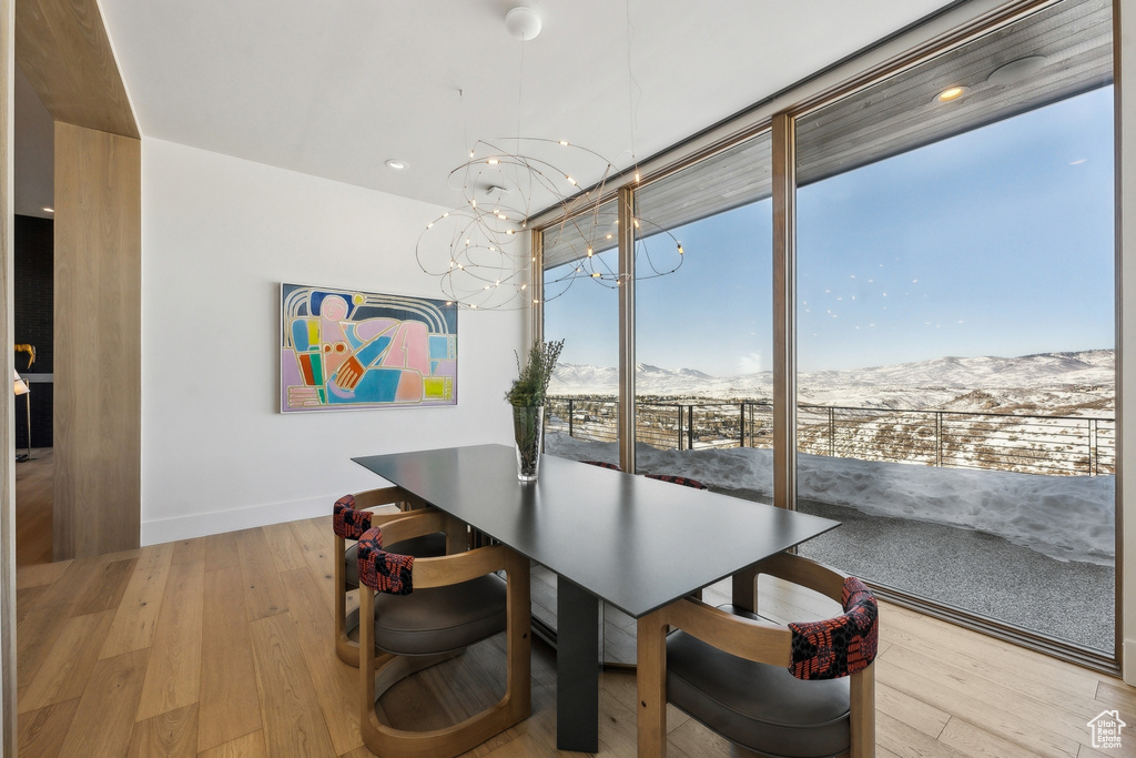 Dining room featuring a wall of windows, a mountain view, and light hardwood / wood-style flooring