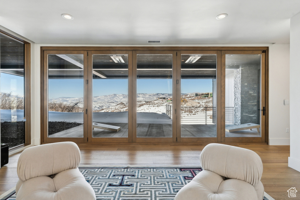 Doorway to outside featuring hardwood / wood-style flooring, floor to ceiling windows, and a mountain view