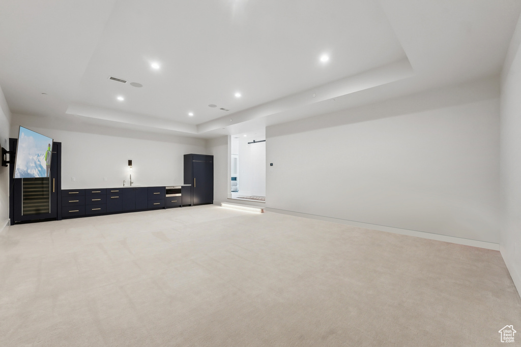 Interior space with light carpet and a tray ceiling