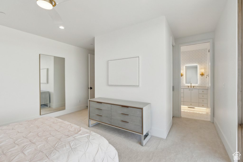 Bedroom featuring light carpet, connected bathroom, baseboards, recessed lighting, and a sink