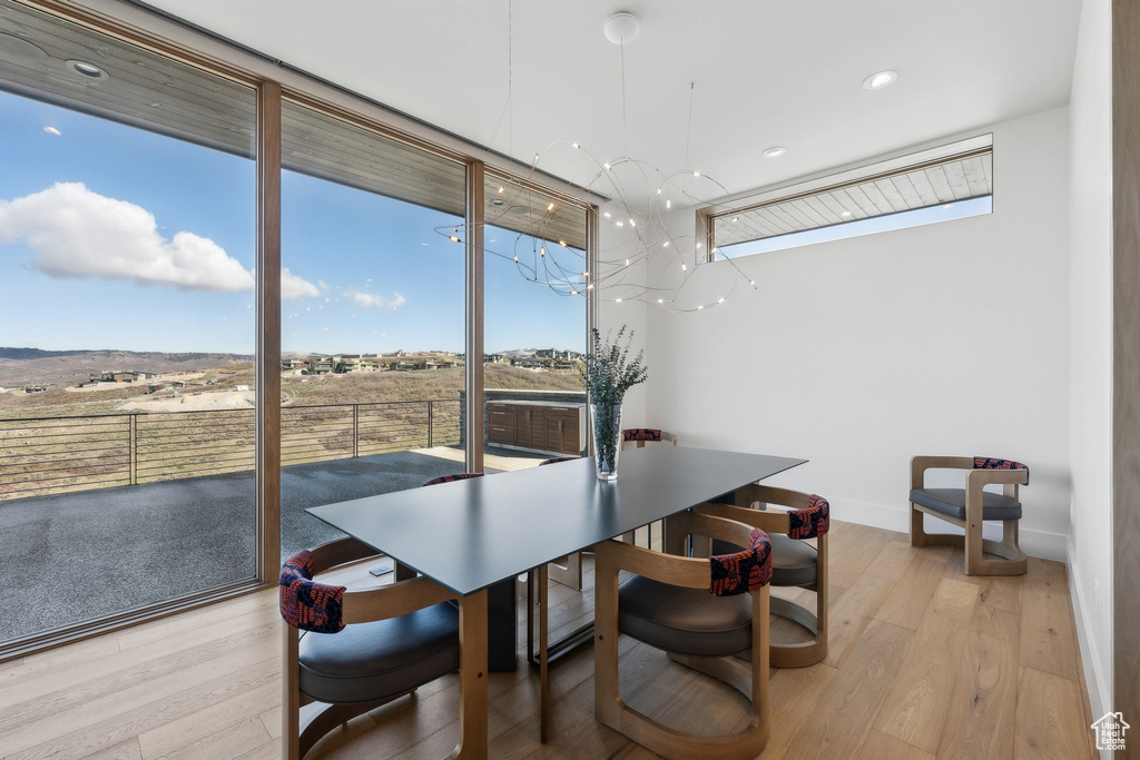 Dining room with a chandelier, light wood-type flooring, baseboards, and recessed lighting