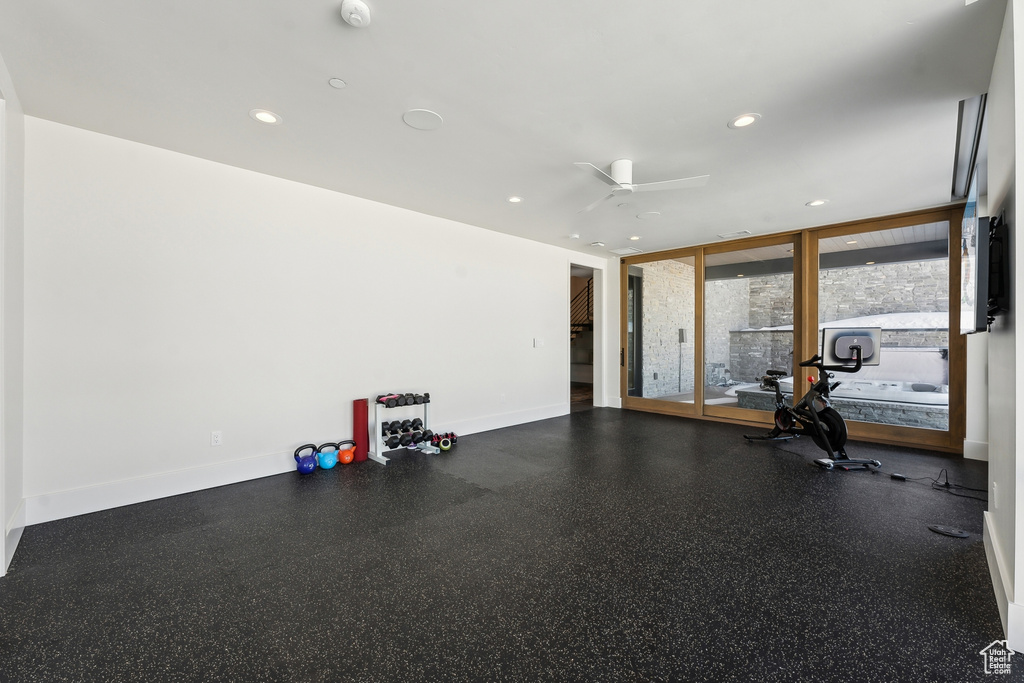 Workout area featuring floor to ceiling windows and ceiling fan