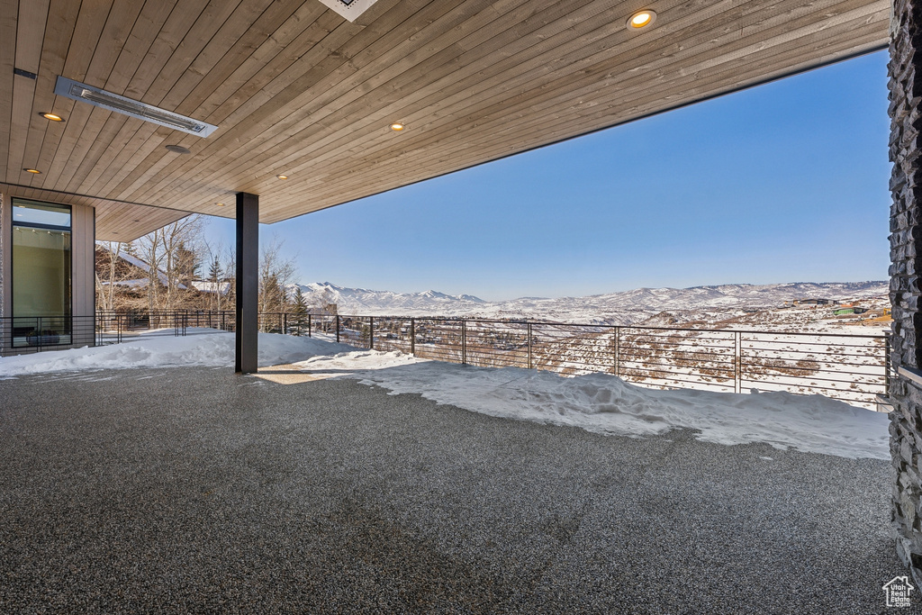 Yard layered in snow featuring a mountain view