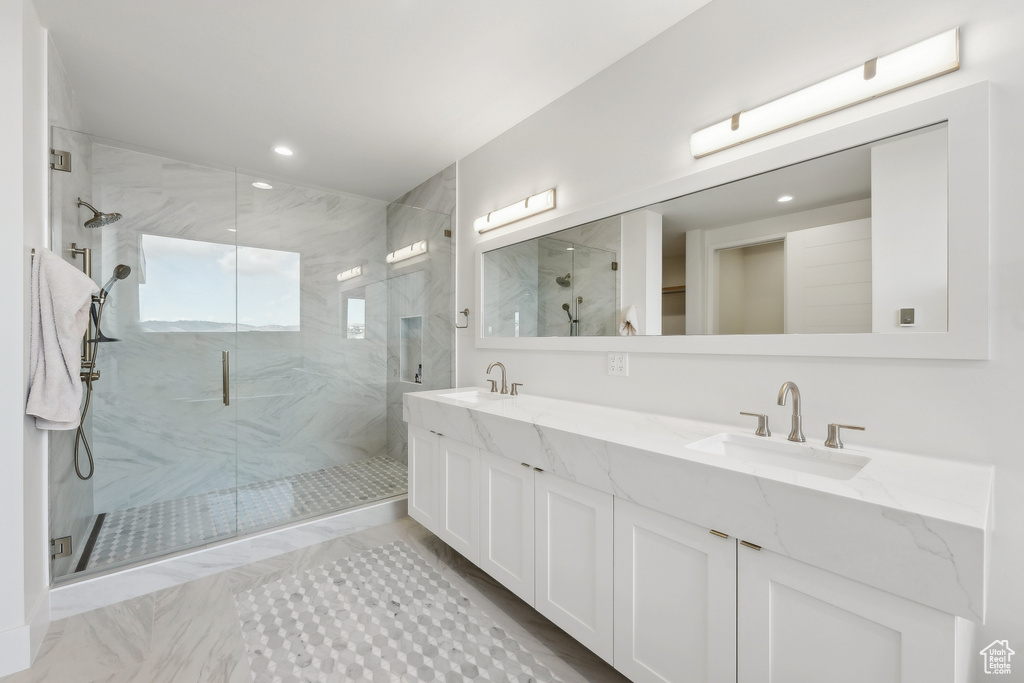 Bathroom featuring a marble finish shower, double vanity, marble finish floors, and recessed lighting