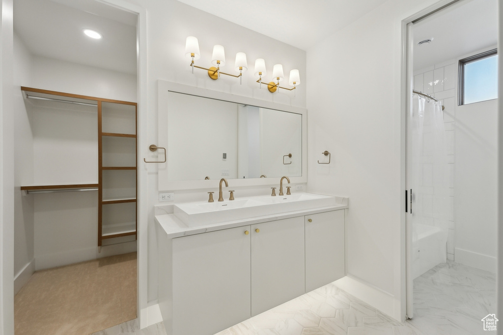 Full bathroom with double vanity, baseboards, shower / tub combo with curtain, a spacious closet, and recessed lighting