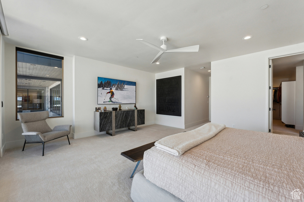 Bedroom featuring light carpet, ceiling fan, and white fridge