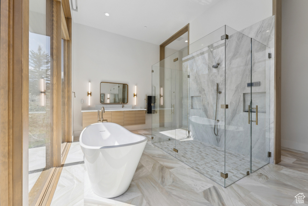 Bathroom with a freestanding bath and a marble finish shower