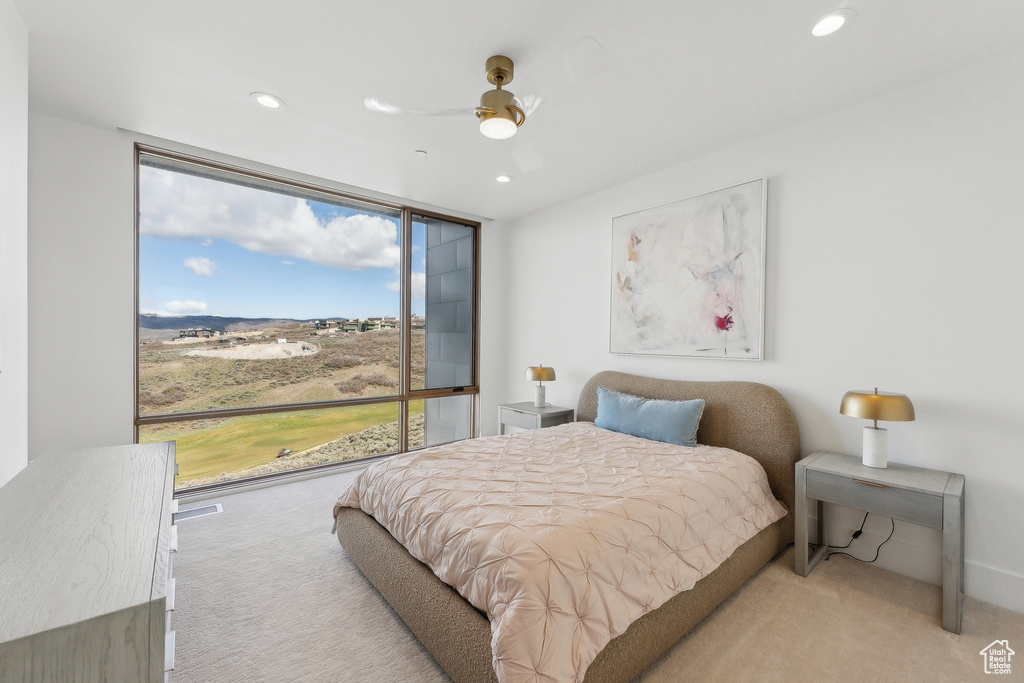 Bedroom featuring light carpet, recessed lighting, a wall of windows, and a ceiling fan