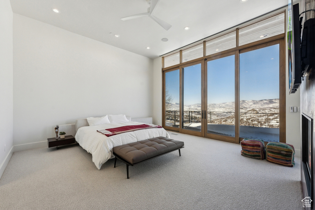 Carpeted bedroom with expansive windows, a mountain view, and access to outside