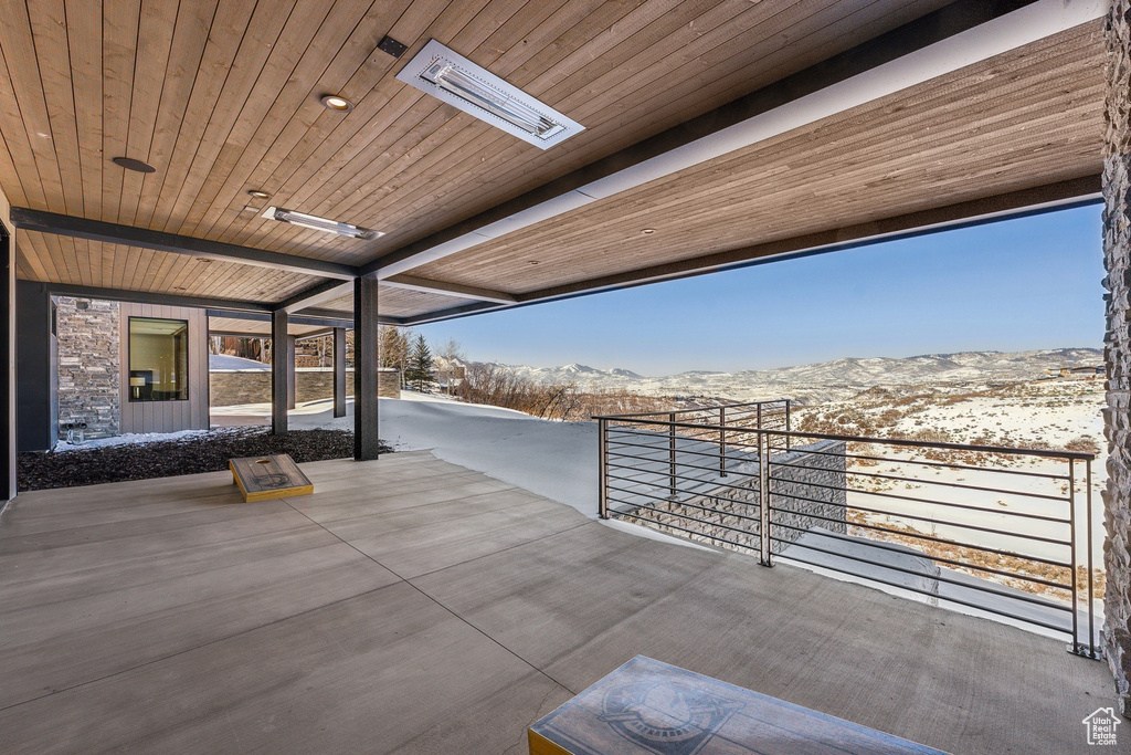 Snow covered patio featuring a mountain view