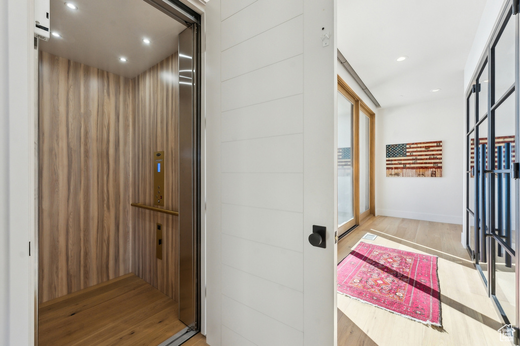 Hall featuring elevator and light wood-type flooring