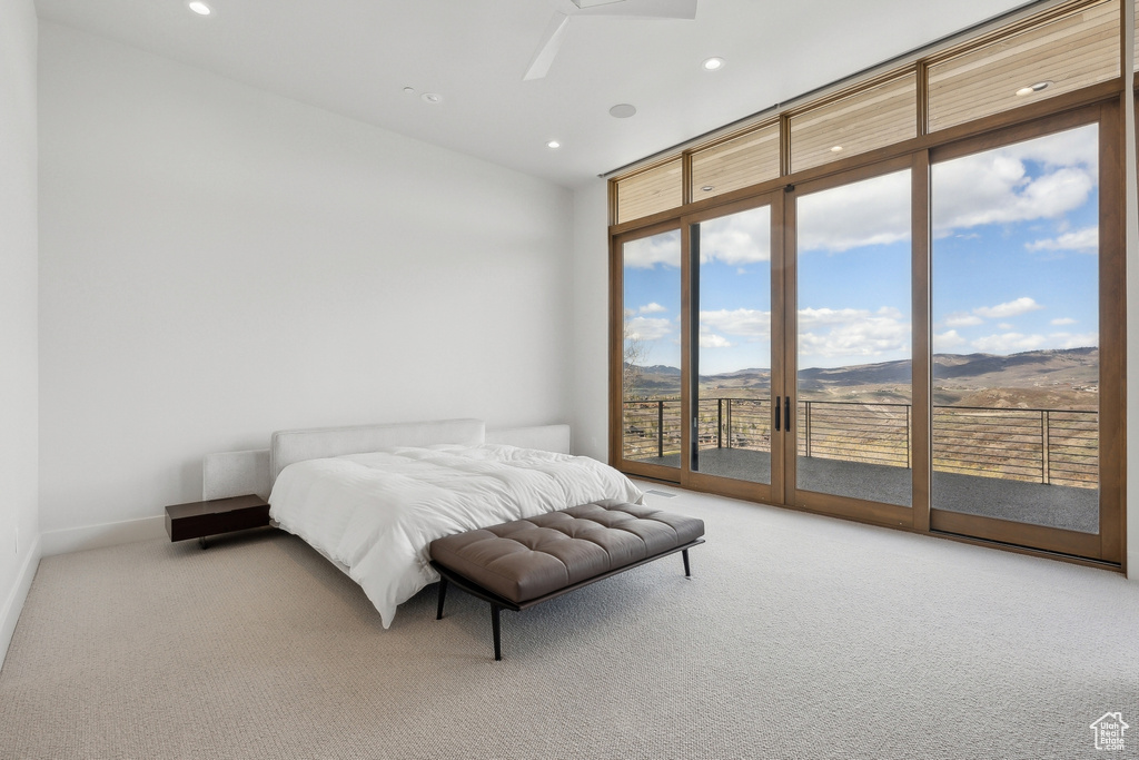 Bedroom featuring carpet, access to exterior, recessed lighting, a mountain view, and expansive windows