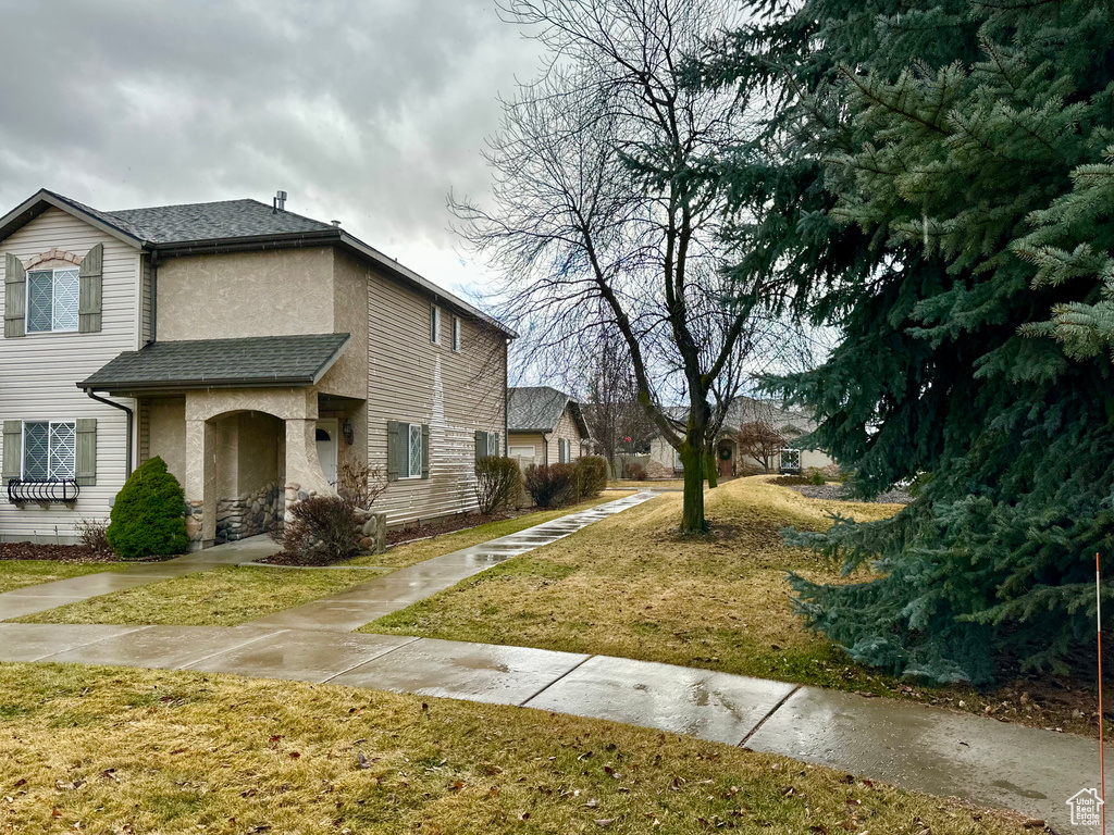 View of side of home with a yard