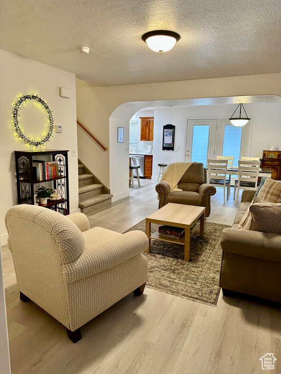 Living room with light hardwood / wood-style floors and a textured ceiling