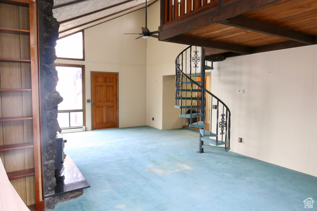 Interior space with baseboard heating, ceiling fan, a healthy amount of sunlight, and carpet