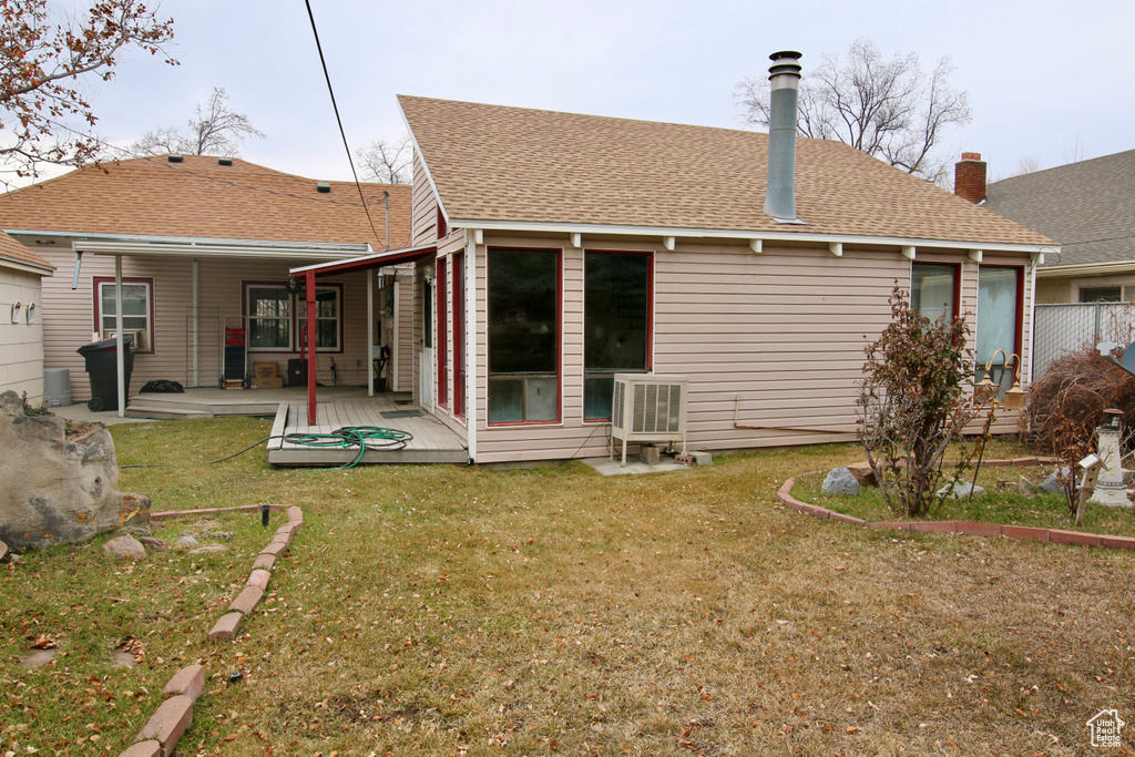 Back of house with a wooden deck and a yard