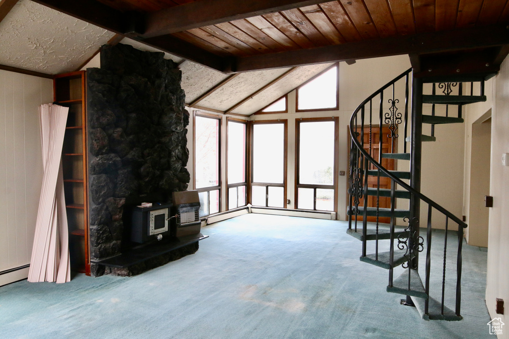 Unfurnished living room with carpet floors, wooden ceiling, lofted ceiling with beams, and a wood stove