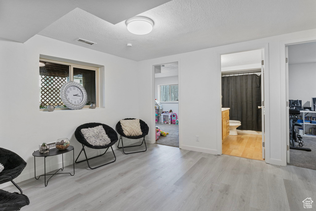 Sitting room featuring a textured ceiling and light hardwood / wood-style flooring