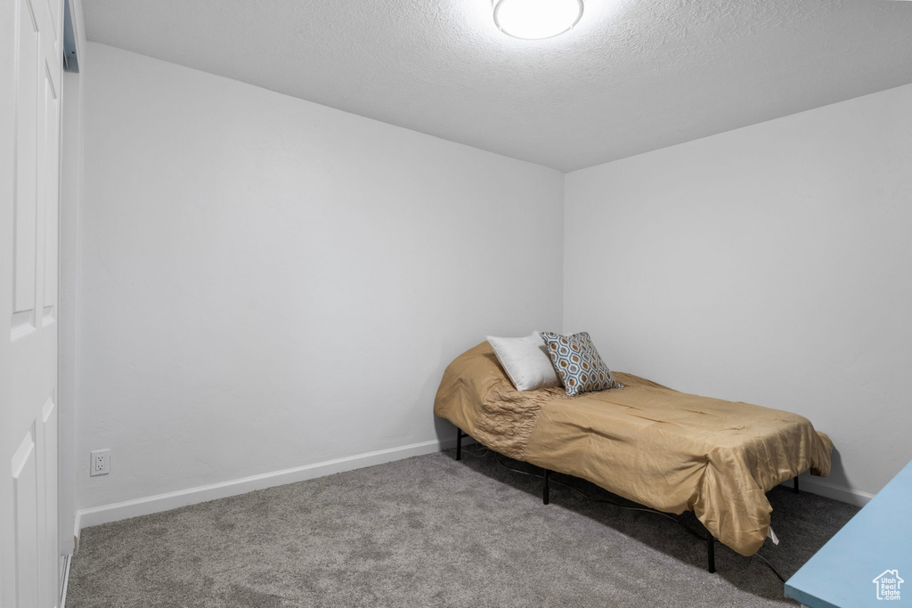 Bedroom with a textured ceiling and carpet flooring