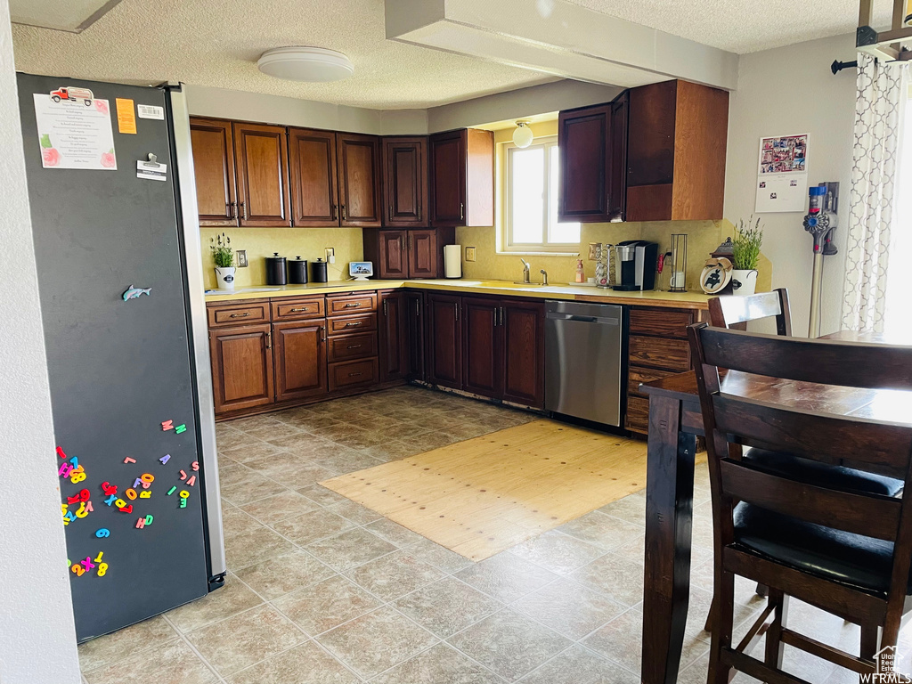 Kitchen featuring appliances with stainless steel finishes, sink, and a textured ceiling